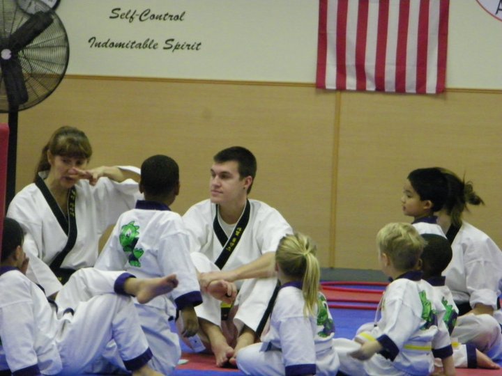 Martial arts student practices punches on a heavy bag during a training exercise.