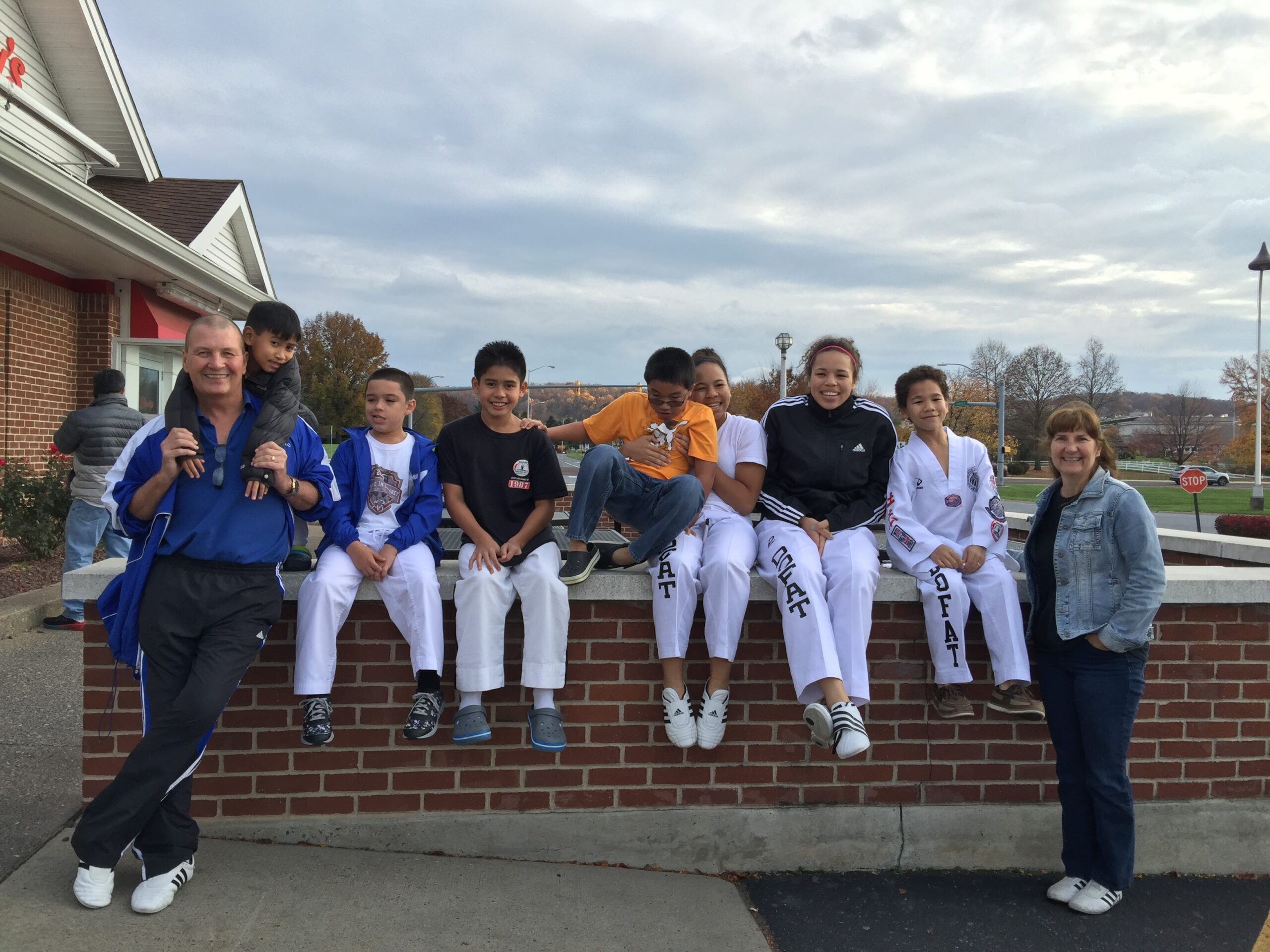 Martial arts students seated outside